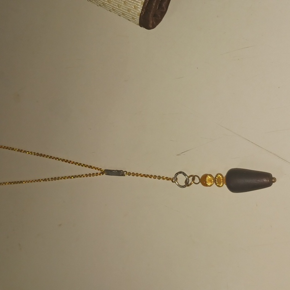 Gold tone necklace with brown and amber pendant